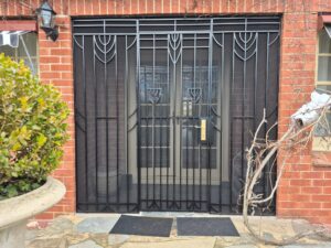 Custom black powder-coated steel security door installed on an Adelaide home by BIC Industries